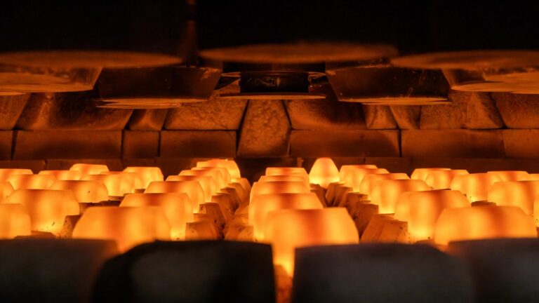 Aluminum billets glowing orange inside an industrial heat treatment furnace
